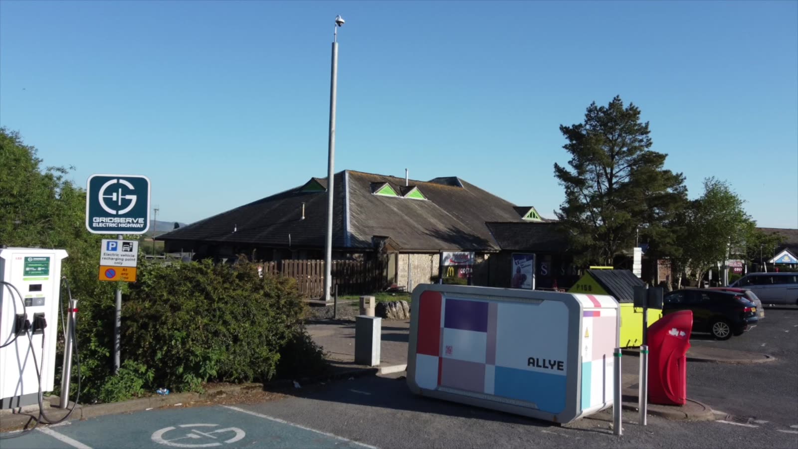 Allye MAX battery unit beside EV chargers in a service station car park